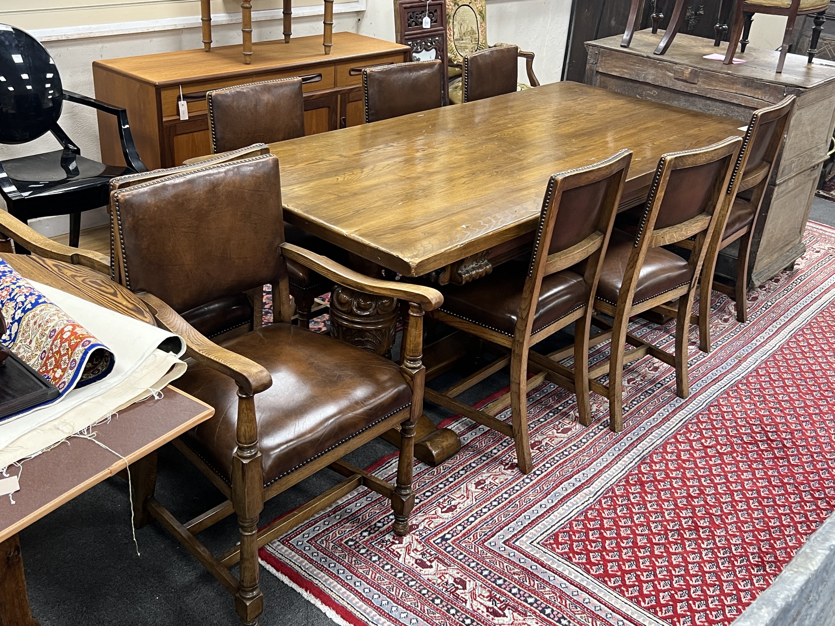 An 18th century style oak refectory dining table, length 198cm, height 76cm and eight oak dining chairs, two with arms